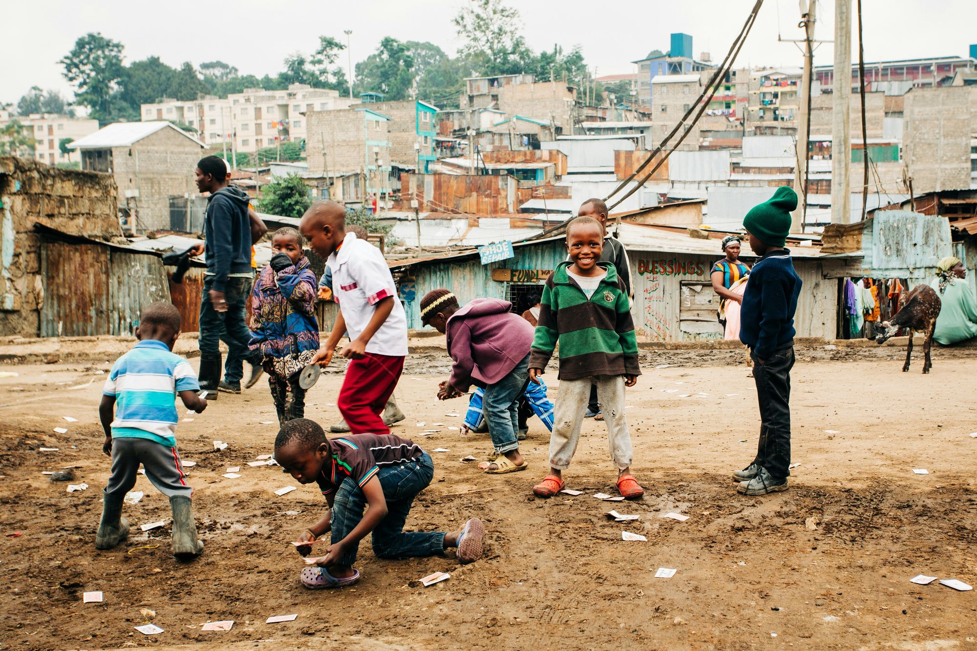 Children playing football on a dirt pitch in a Nairobi neighbourhood