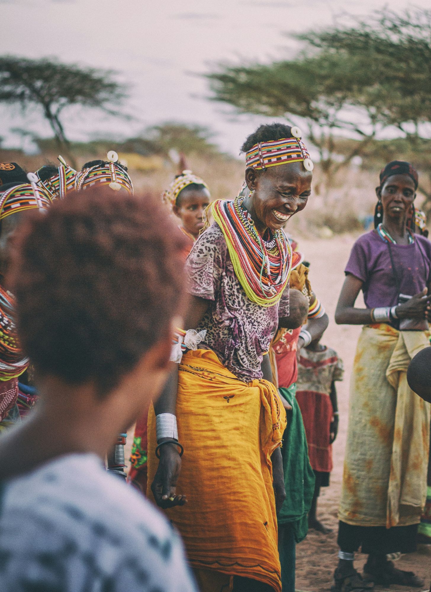 Women in beaded jewellery smiling and celebrating together