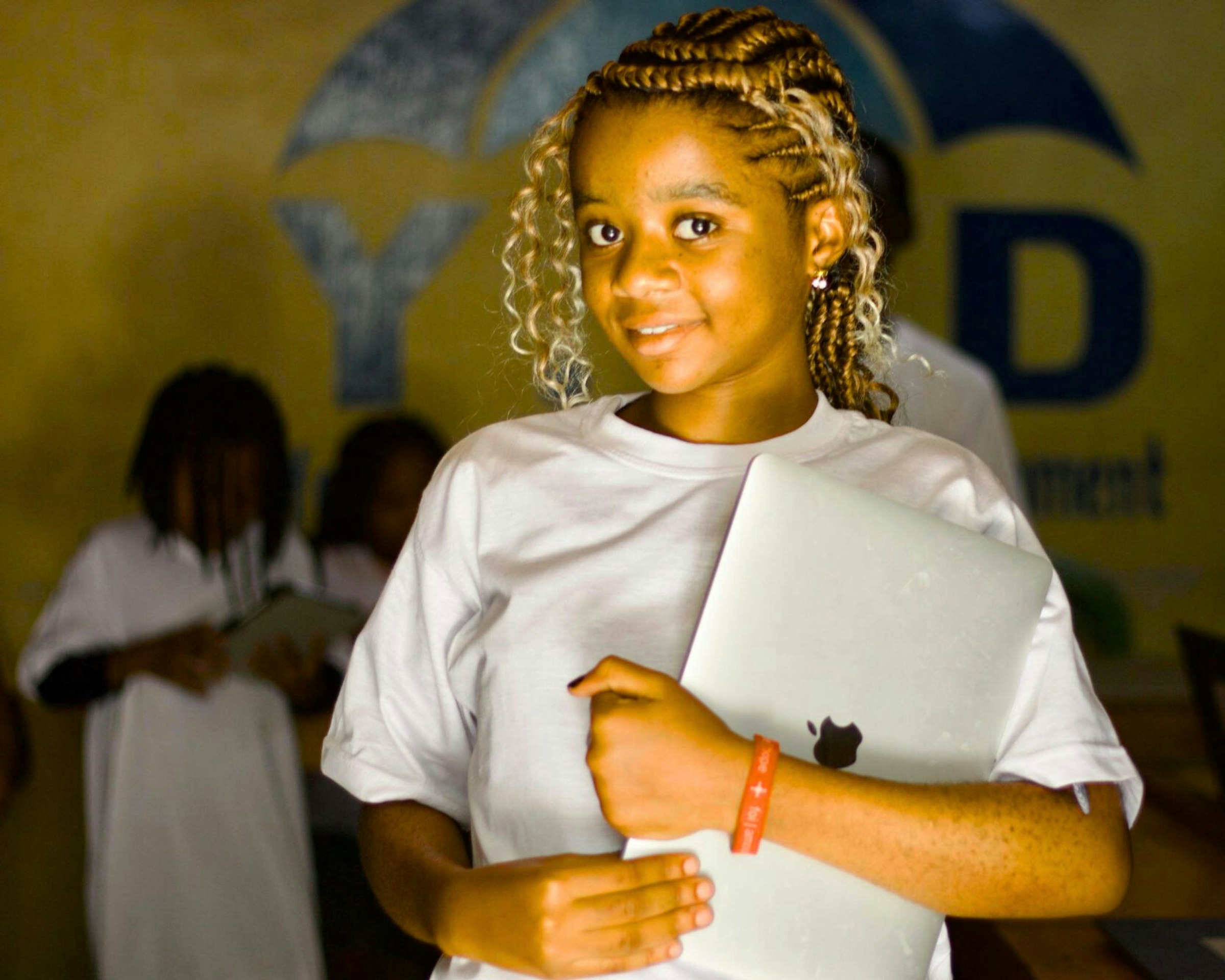 A young woman with braided hair holding a laptop